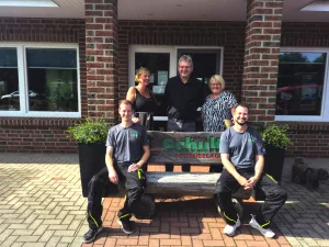 Das Team von Teppich Schult vor dem Geschäft in Wanna – Spezialisten für Bodenbeläge, Parkettaufbereitung und Treppenrenovierungen.